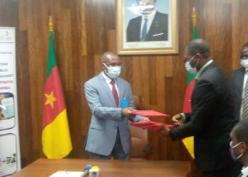 Minister Manaouda Malachie (L), and Hendzi Michel (R) exchanging documents signed to seal the donation
