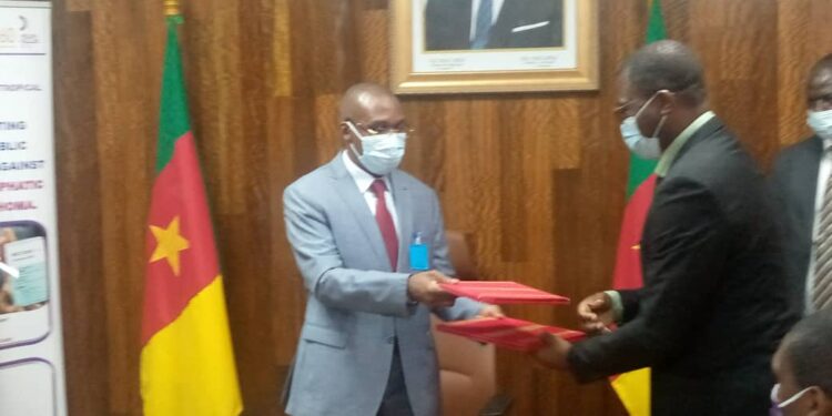 Minister Manaouda Malachie (L), and Hendzi Michel (R) exchanging documents signed to seal the donation