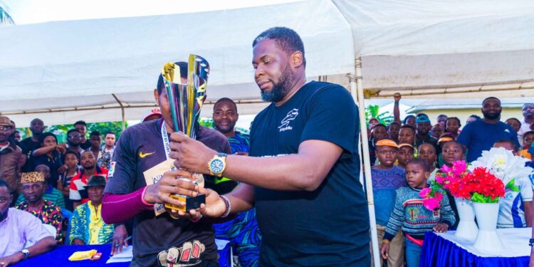 Edwin Eselem, promoter of the tournament handing over the trophy to the winning team