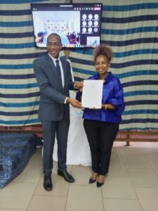 Wanja KAARIA (R), receiving her own pin of recognition and certificate from the regional director