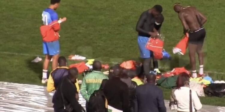 Players changing on the turf after refusing to use the dressing room in Algeria