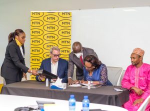 Officials from both telecom companies signing the agreement in Johannesburg