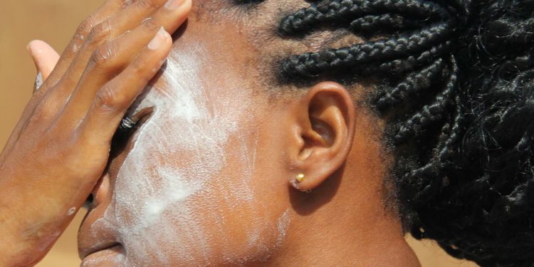 African girl applying beauty product on the face (credit rfi)