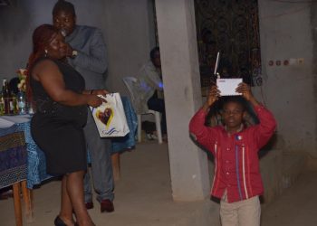 One of the beneficiaries presenting his envelope to the Kejom community