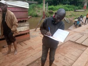 Ferry boat worker, registering transactions inside his log book