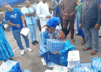 Madam Fadimatou Aboubakar, technical adviser no. 2, presenting Christmas gifts to one of the children at the 2022 Christmas tree ceremony