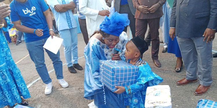 Madam Fadimatou Aboubakar, technical adviser no. 2, presenting Christmas gifts to one of the children at the 2022 Christmas tree ceremony