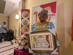 Esther N. Omam, Executive Director of Reach Out Cameroon brandishing the award received from Newswatch 