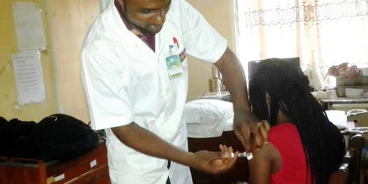 Doctor administering the cervical cancer vaccine in Cameroon to a child (Credit CBCHS)