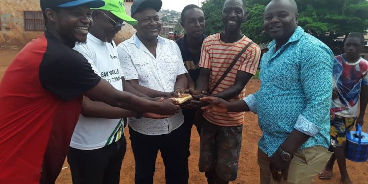 Hon. Agho Oliver Bamenju handing over the package to the community