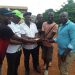 Hon. Agho Oliver Bamenju handing over the package to the community