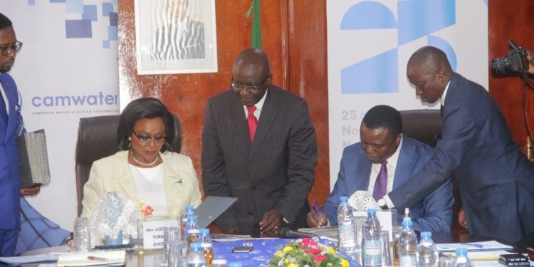 Judith Yah Sunday and Blaise Moussa signing the agreement